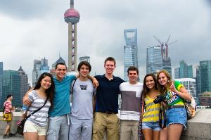 Group of students in Shanghai, with city skyline behind them. 