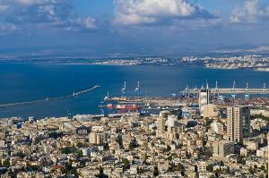 a view of the city of Haifa with several buildings, a few skyscrapers, and a view of the ocean.
