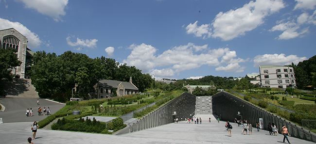 A photo of the university and a descending slope into an underground classroom