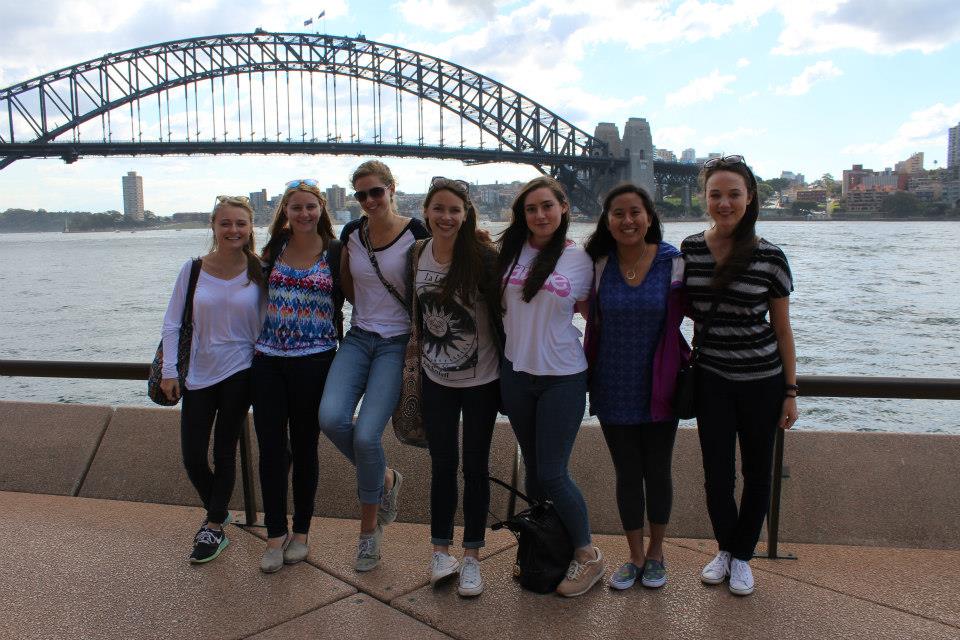 Wheaton studens along a river in Wollongong, with a bridge behind them. 