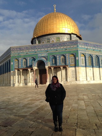 A student standing in front of a building with a gold dome